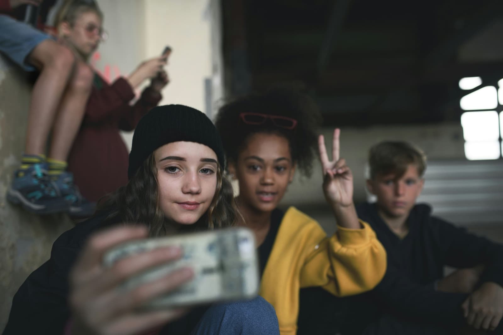 A group of teens taking a selfie together, one flashing a peace sign